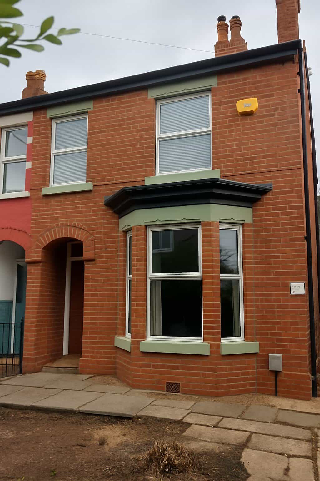 Traditional red brick terraced house with bay window and chimney stacks in Warrington.